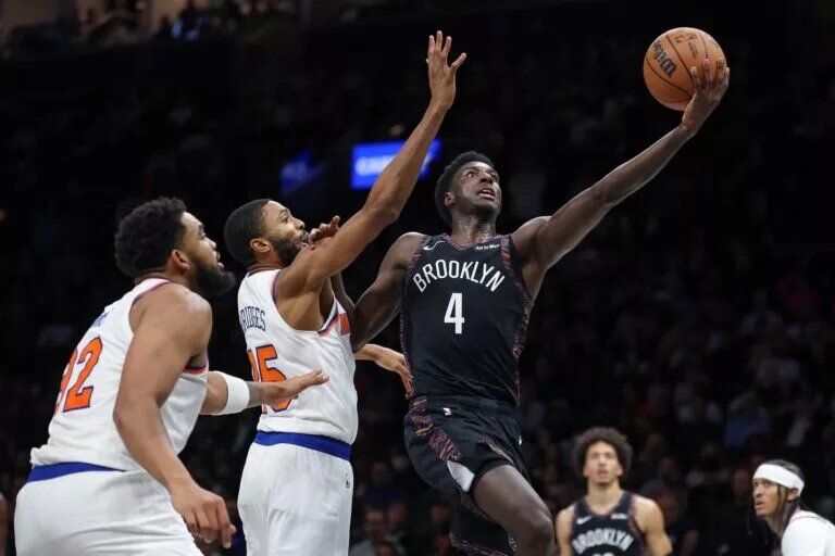 Nov 24, 2025; Brooklyn, New York, USA; Brooklyn Nets guard Drake Powell (4) goes to the basket as New York Knicks guard Mikal Bridges (25) defends during the second half at Barclays Center. Mandatory Credit: Vincent Carchietta-Imagn Images