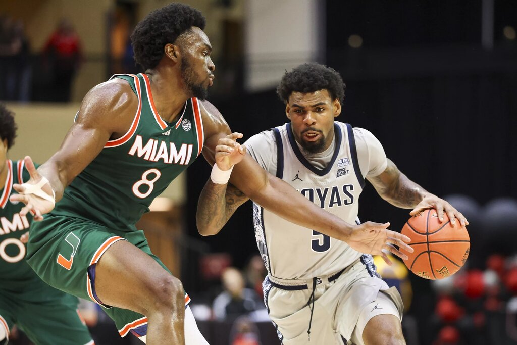 Georgetown Hoyas guard Kj Lewis (5) is guarded by Miami (FL) Hurricanes center Ernest Udeh Jr. (8) in the first half during the ESPN Events Invitational at State Farm Field House.