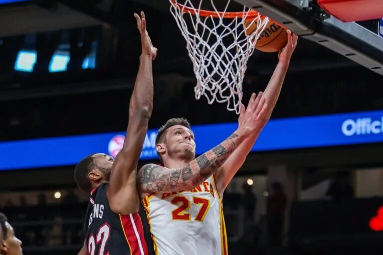 Oct 13, 2025; Atlanta, Georgia, USA; Atlanta Hawks guard Vít Krejčí (27) jumps for the layup against Miami Heat forward Andrew Wiggins (22) during the first quarter at State Farm Arena. Mandatory Credit: Jordan Godfree-Imagn Images
