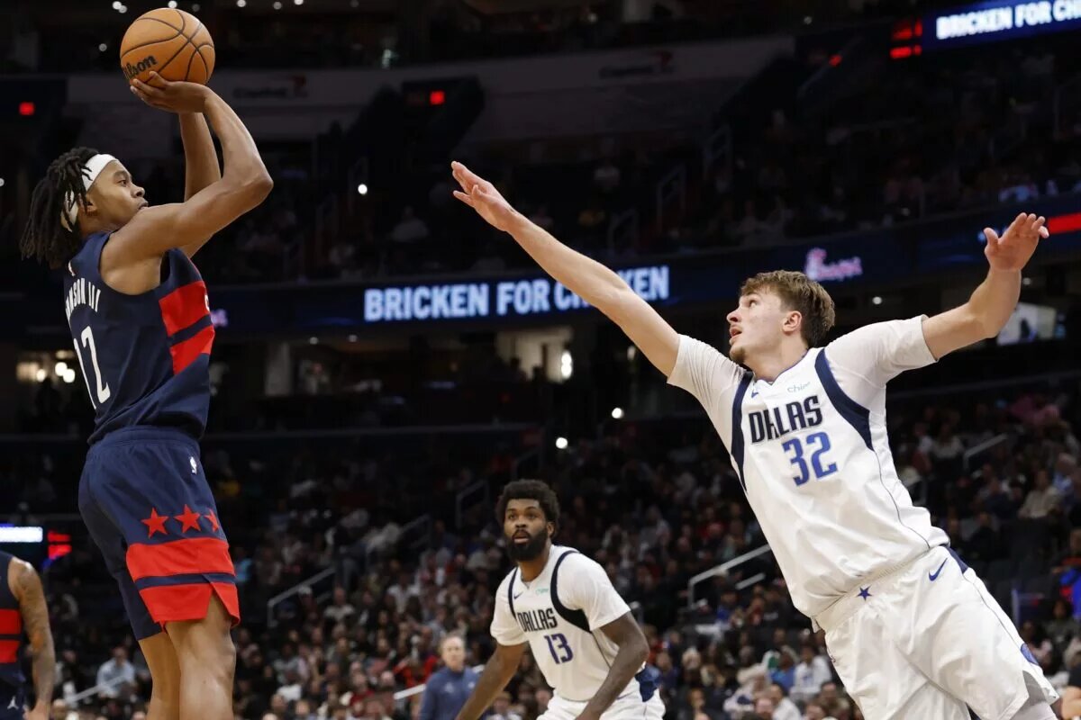 Nov 8, 2025; Washington, District of Columbia, USA; Washington Wizards guard Tre Johnson (12) shoots the ball over Dallas Mavericks forward Cooper Flagg (32) in the second half at Capital One Arena. Mandatory Credit: Geoff Burke-Imagn Images