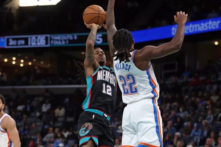 Nov 9, 2025; Memphis, Tennessee, USA; Memphis Grizzlies guard Ja Morant (12) shoots as Oklahoma City Thunder guard Cason Wallace (22) defends during the third quarter at FedExForum. Mandatory Credit: Petre Thomas-Imagn Images