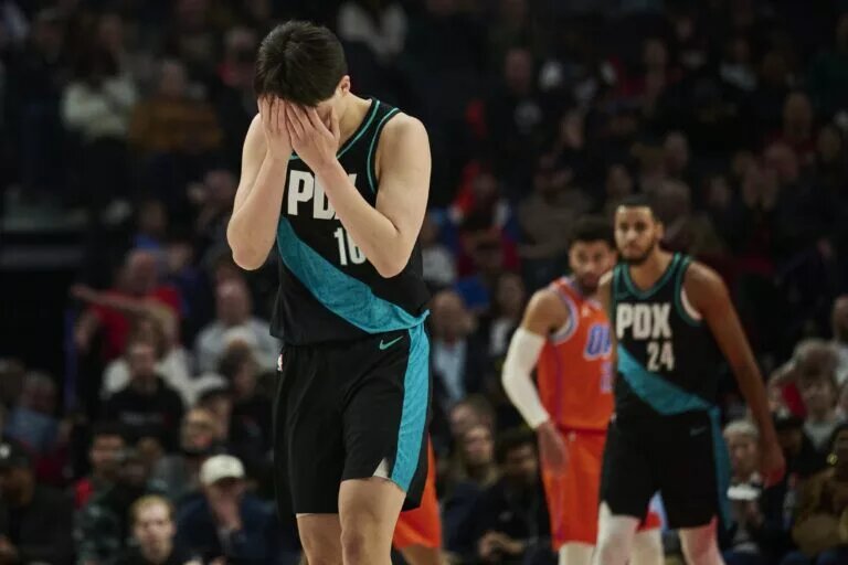 Nov 30, 2025; Portland, Oregon, USA; Portland Trail Blazers center Yang Hansen (16) reacts after missing a three point basket during the first half against the Oklahoma City Thunder at Moda Center. Mandatory Credit: Troy Wayrynen-Imagn Images
