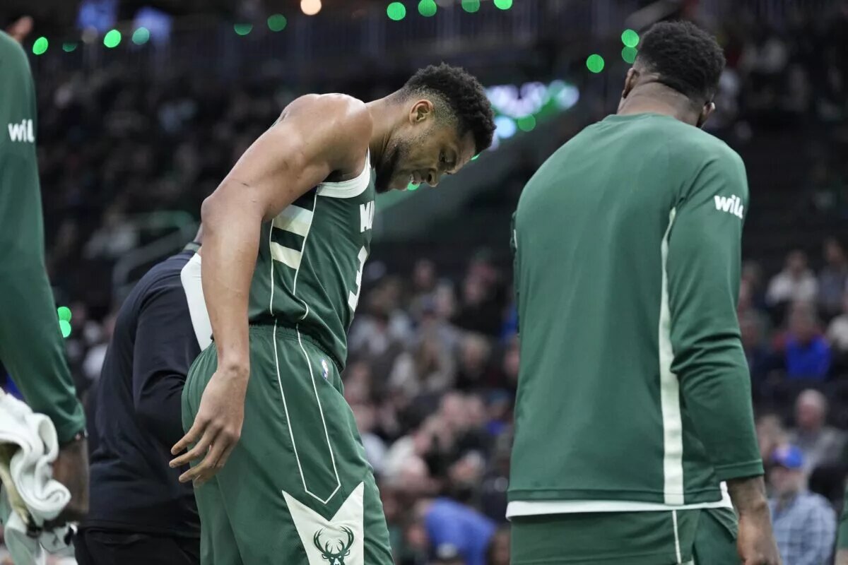 Milwaukee Bucks forward Giannis Antetokounmpo (34) grimaces as he limps off the court after going down with an injury in the first half against the Detroit Pistons at Fiserv Forum.