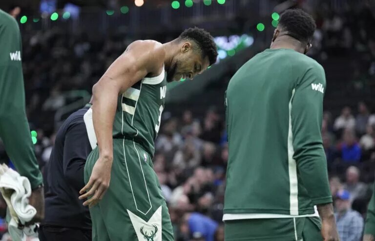 Milwaukee Bucks forward Giannis Antetokounmpo (34) grimaces as he limps off the court after going down with an injury in the first half against the Detroit Pistons at Fiserv Forum.