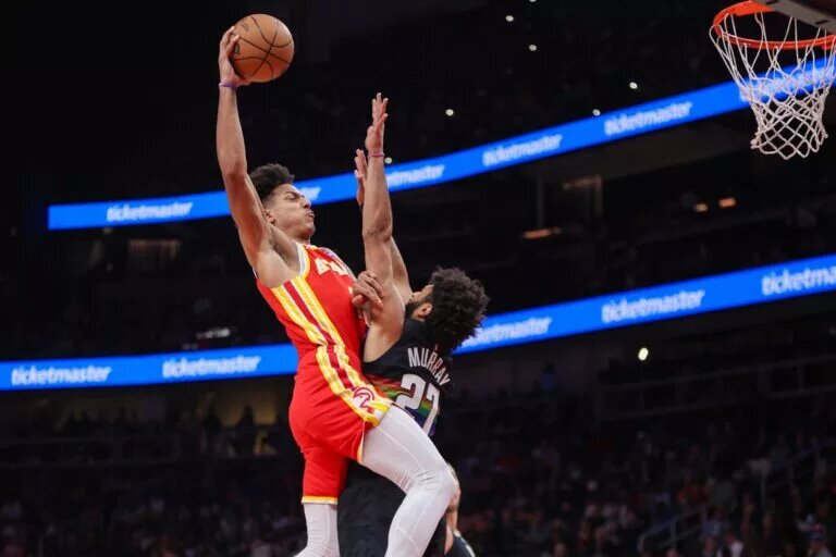 Dec 5, 2025; Atlanta, Georgia, USA; Atlanta Hawks forward Jalen Johnson (1) dunks over Denver Nuggets guard Jamal Murray (27) in the second quarter at State Farm Arena. Mandatory Credit: Brett Davis-Imagn Images
