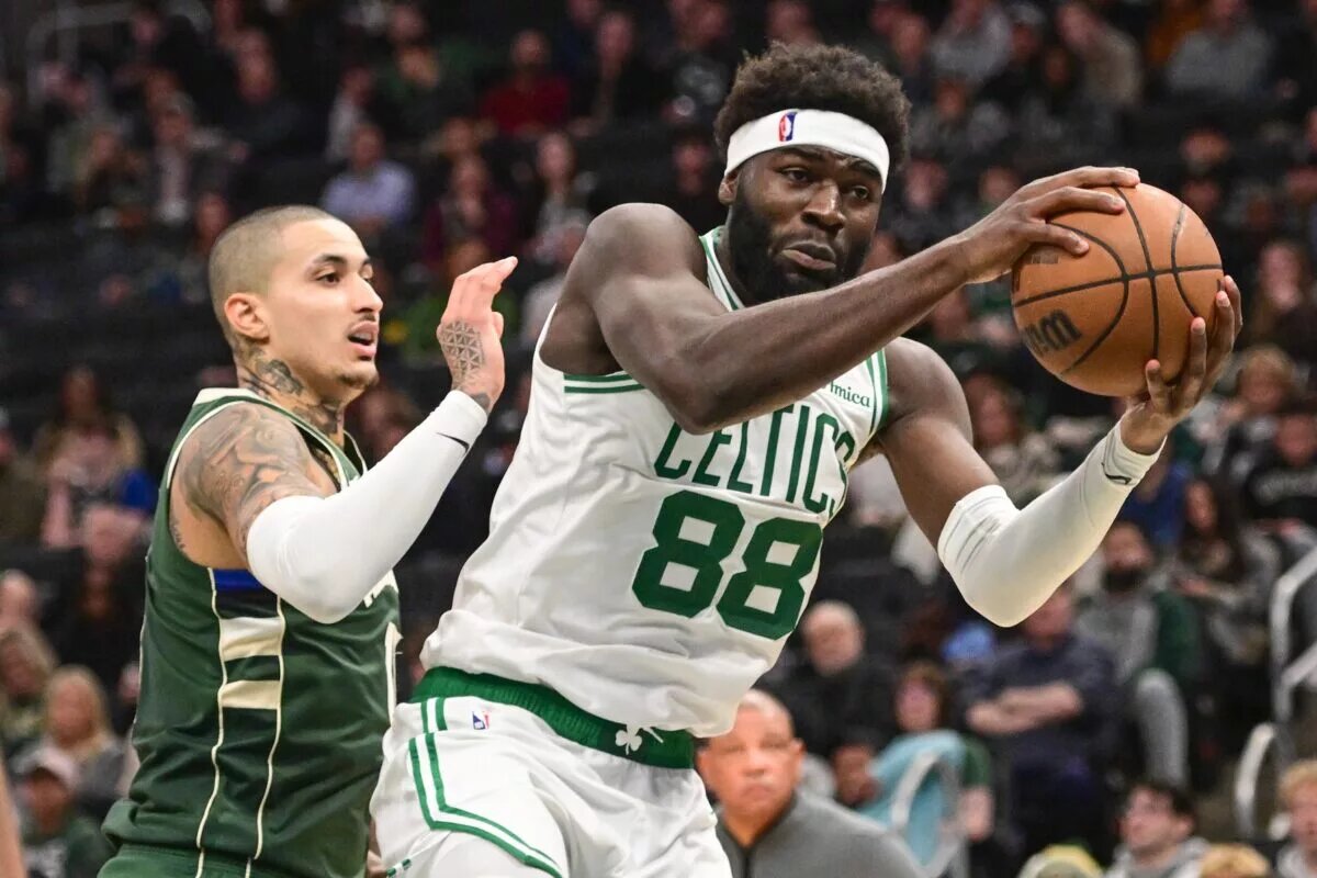 Dec 11, 2025; Milwaukee, Wisconsin, USA; Boston Celtics center Neemias Queta (88) grabs a rebound against Milwaukee Bucks forward Kyle Kuzma (18) in the fourth quarter at Fiserv Forum. Mandatory Credit: Benny Sieu-Imagn Images