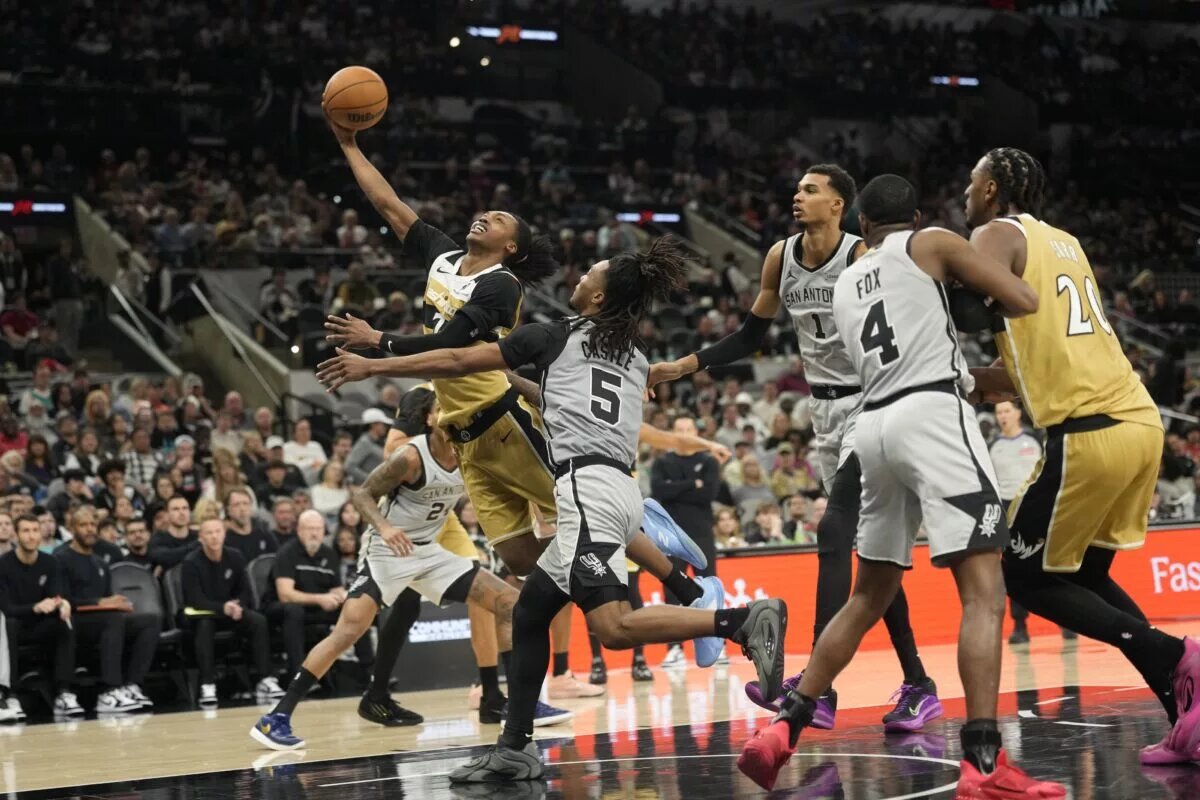 Dec 18, 2025; San Antonio, Texas, USA; Washington Wizards guard Bub Carrington (7) drives past San Antonio Spurs guard Stephon Castle (5) during the second half at Frost Bank Center. Mandatory Credit: Scott Wachter-Imagn Images