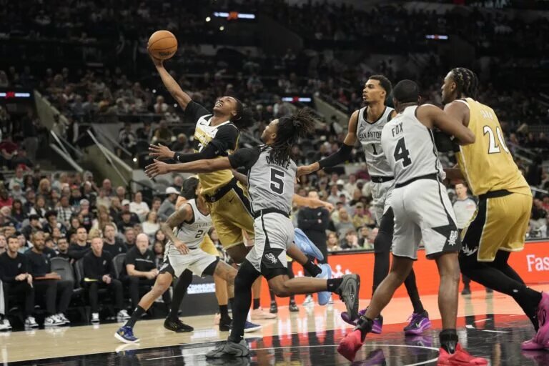Dec 18, 2025; San Antonio, Texas, USA; Washington Wizards guard Bub Carrington (7) drives past San Antonio Spurs guard Stephon Castle (5) during the second half at Frost Bank Center. Mandatory Credit: Scott Wachter-Imagn Images