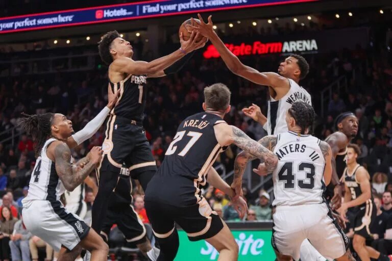 Atlanta Hawks forward Jalen Johnson (1) and San Antonio Spurs forward Victor Wembanyama (1) reach for a rebound in the second quarter at State Farm Arena.