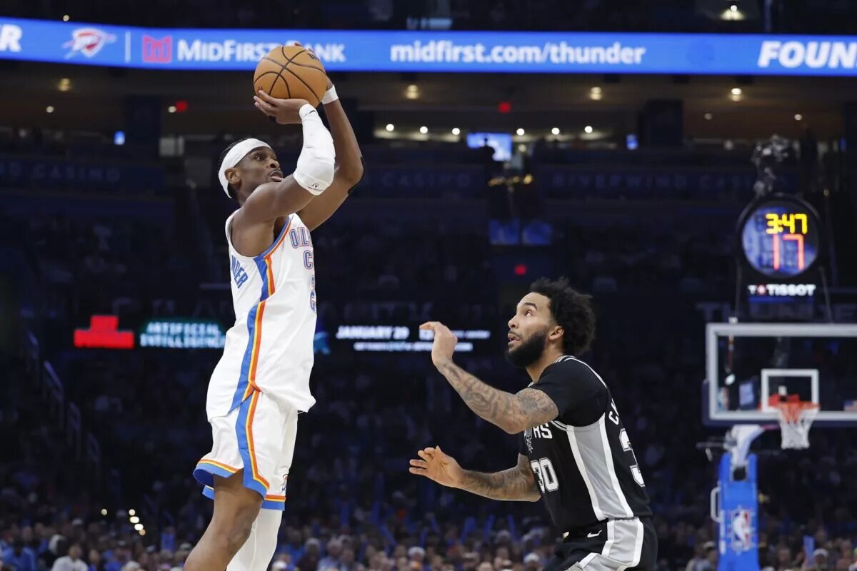 Dec 25, 2025; Oklahoma City, Oklahoma, USA; Oklahoma City Thunder guard Shai Gilgeous-Alexander (2) shoots a three point basket over San Antonio Spurs forward Julian Champagnie (30) during the second half at Paycom Center. Mandatory Credit: Alonzo Adams-Imagn Images
