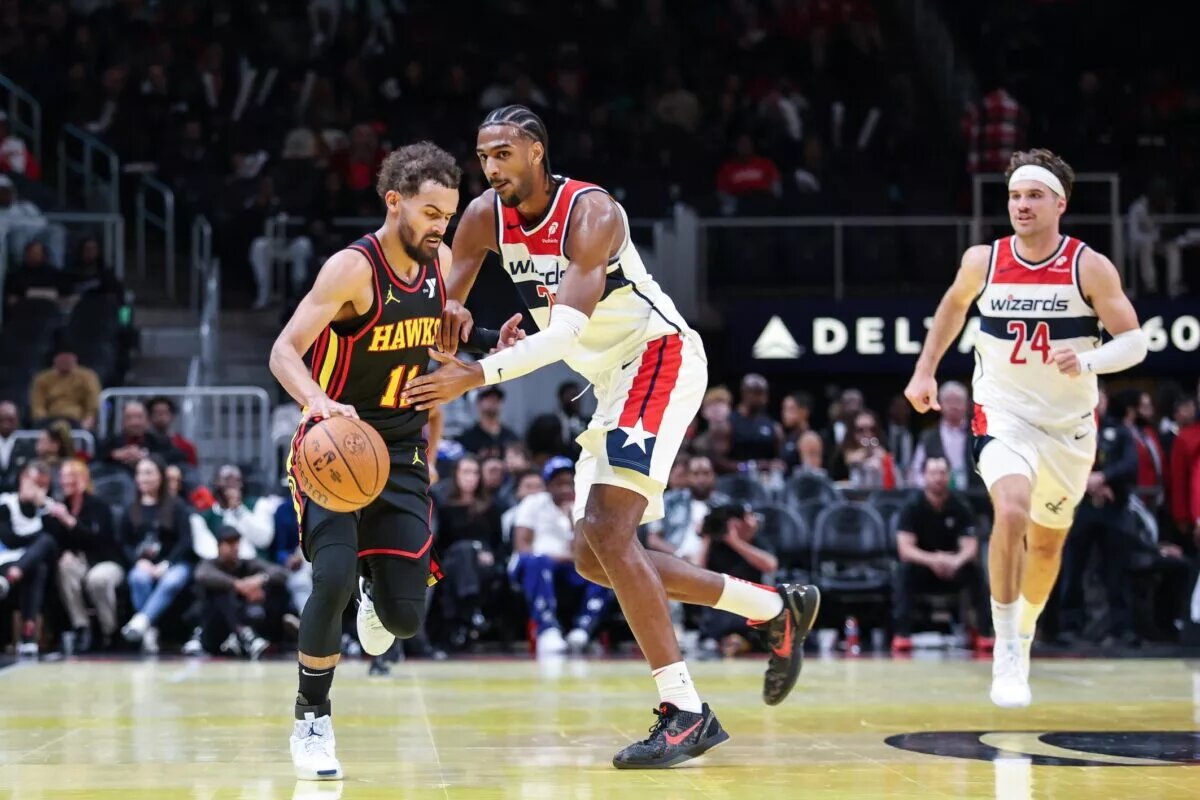 Washington Wizards forward Alexandre Sarr (20) fouls against Atlanta Hawks guard Trae Young (11) during the fourth quarter at State Farm Arena.