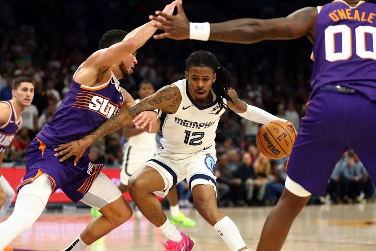 Memphis Grizzlies guard Ja Morant dribbles against Phoenix Suns defenders Devin Booker and Royce O'Neale