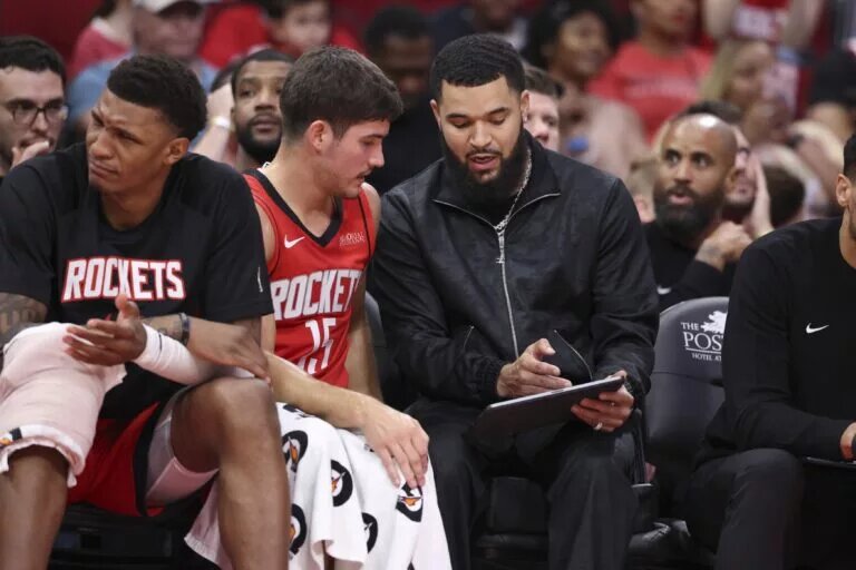 Houston Rockets guard Reed Sheppard (15) talks with guard Fred VanVleet (right) on the bench during the game against the Orlando Magic at Toyota Center.