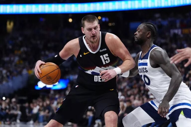 Minnesota Timberwolves forward Julius Randle (30) defends on Denver Nuggets center Nikola Jokic (15) at Ball Arena.