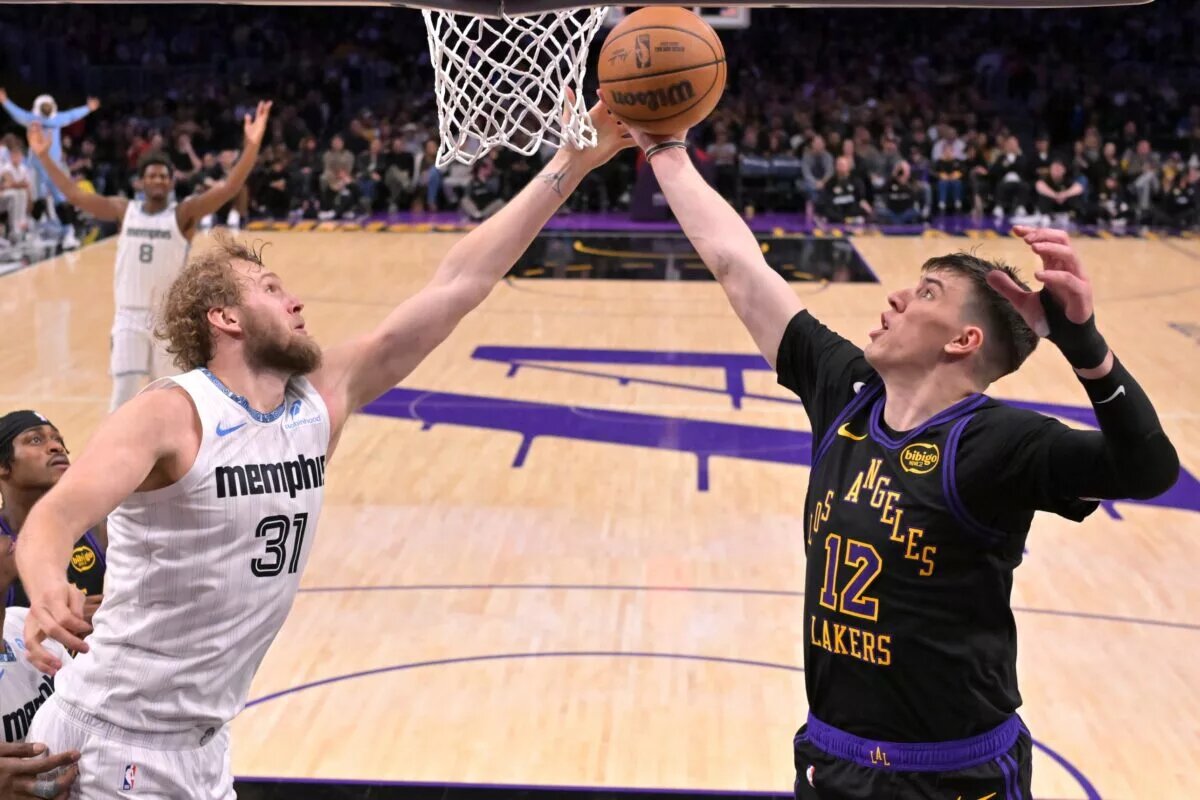 Jan 2, 2026; Los Angeles, California, USA; Memphis Grizzlies center Jock Landale (31) and Los Angeles Lakers forward Jake Laravia (12) reach for a rebound in the second half at Crypto.com Arena. Mandatory Credit: Jayne Kamin-Oncea-Imagn Images