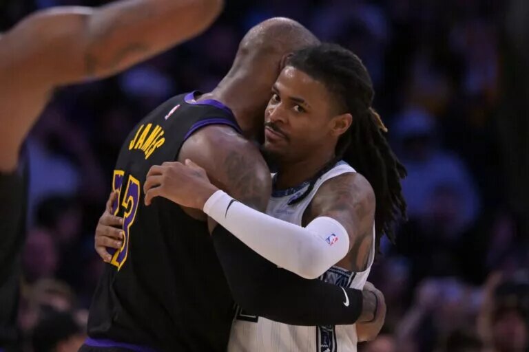 Memphis Grizzlies point guard Ja Morant hugs Los Angeles Lakers forward LeBron James after the game while looking at the camera