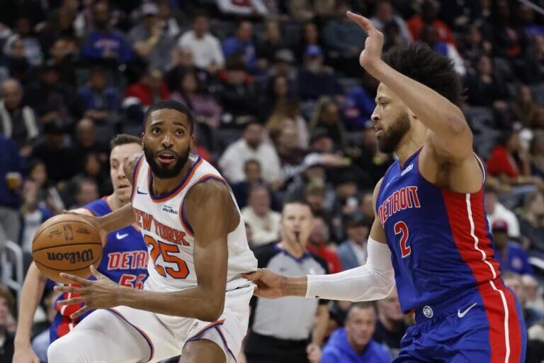 Jan 5, 2026; Detroit, Michigan, USA; New York Knicks guard Mikal Bridges (25) is defended by Detroit Pistons guard Cade Cunningham (2) in the first half at Little Caesars Arena. Mandatory Credit: Rick Osentoski-Imagn Images