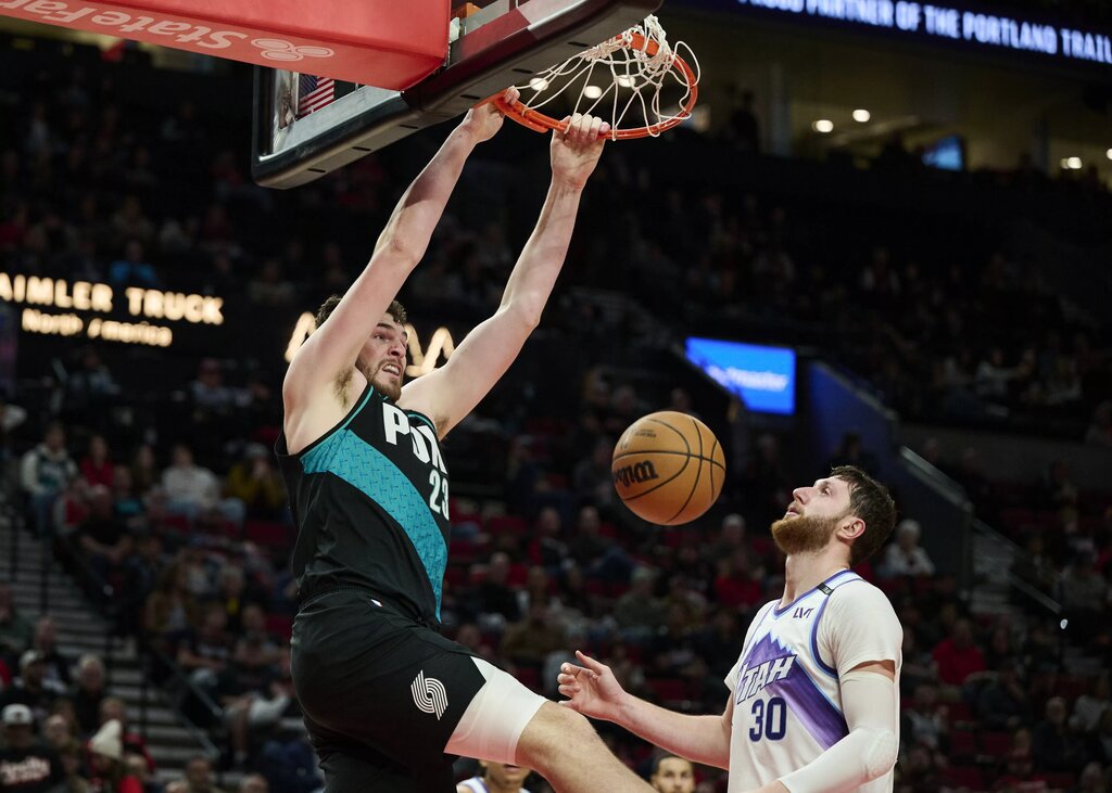 Portland Trail Blazers center Donovan Clingan (23) dunks the ball over Utah Jazz center Jusuf Nurkic (30) during the second half at Moda Center.