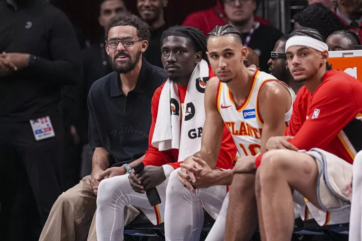 Atlanta Hawks guard Trae Young (11) (left in black shirt) sits on the end of the bench during the game against the New Orleans Pelicans during the second half at State Farm Arena.