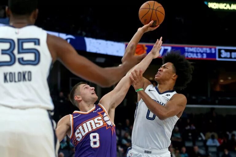 Jan 7, 2026; Memphis, Tennessee, USA; Memphis Grizzlies forward Jaylen Wells (0) shoots as Phoenix Suns guard Grayson Allen (8) defends during the third quarter at FedExForum. Mandatory Credit: Petre Thomas-Imagn Images