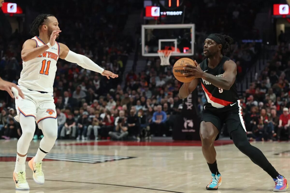 Jan 11, 2026; Portland, Oregon, USA; Portland Trail Blazers guard Jrue Holiday (5) shoots the ball against New York Knicks guard Jalen Brunson (11) during the first half at Moda Center. Mandatory Credit: Jaime Valdez-Imagn Images