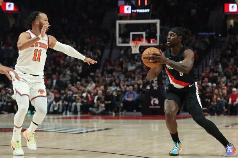 Jan 11, 2026; Portland, Oregon, USA; Portland Trail Blazers guard Jrue Holiday (5) shoots the ball against New York Knicks guard Jalen Brunson (11) during the first half at Moda Center. Mandatory Credit: Jaime Valdez-Imagn Images