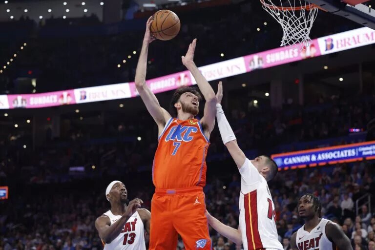 Jan 11, 2026; Oklahoma City, Oklahoma, USA; Oklahoma City Thunder center/forward Chet Holmgren (7) goes up for a basket over Miami Heat guard Tyler Herro (14) during the second half at Paycom Center. Mandatory Credit: Alonzo Adams-Imagn Images