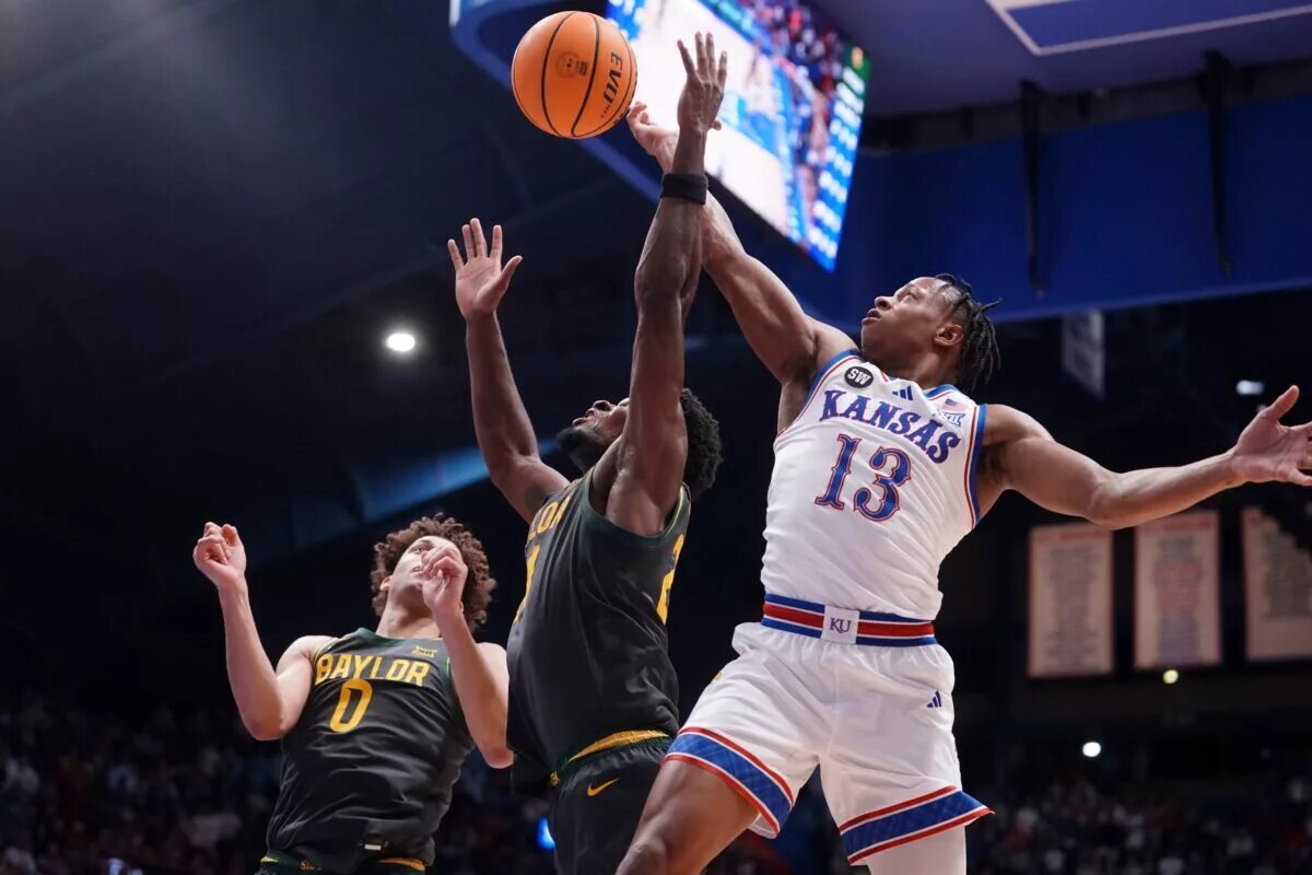 Kansas Jayhawks guard Elmarko Jackson (13) reaches for a rebound against Baylor Bears center Juslin Bodo Bodo (21) during the game inside Allen Fieldhouse on Jan. 16, 2026.