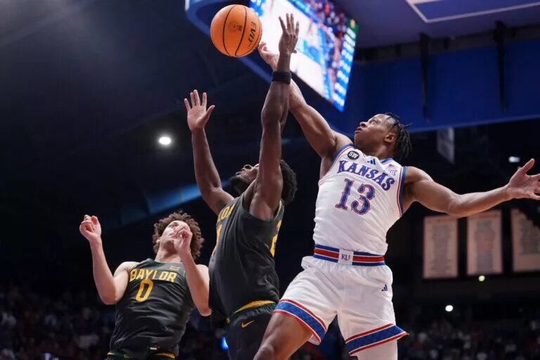 Kansas Jayhawks guard Elmarko Jackson (13) reaches for a rebound against Baylor Bears center Juslin Bodo Bodo (21) during the game inside Allen Fieldhouse on Jan. 16, 2026.