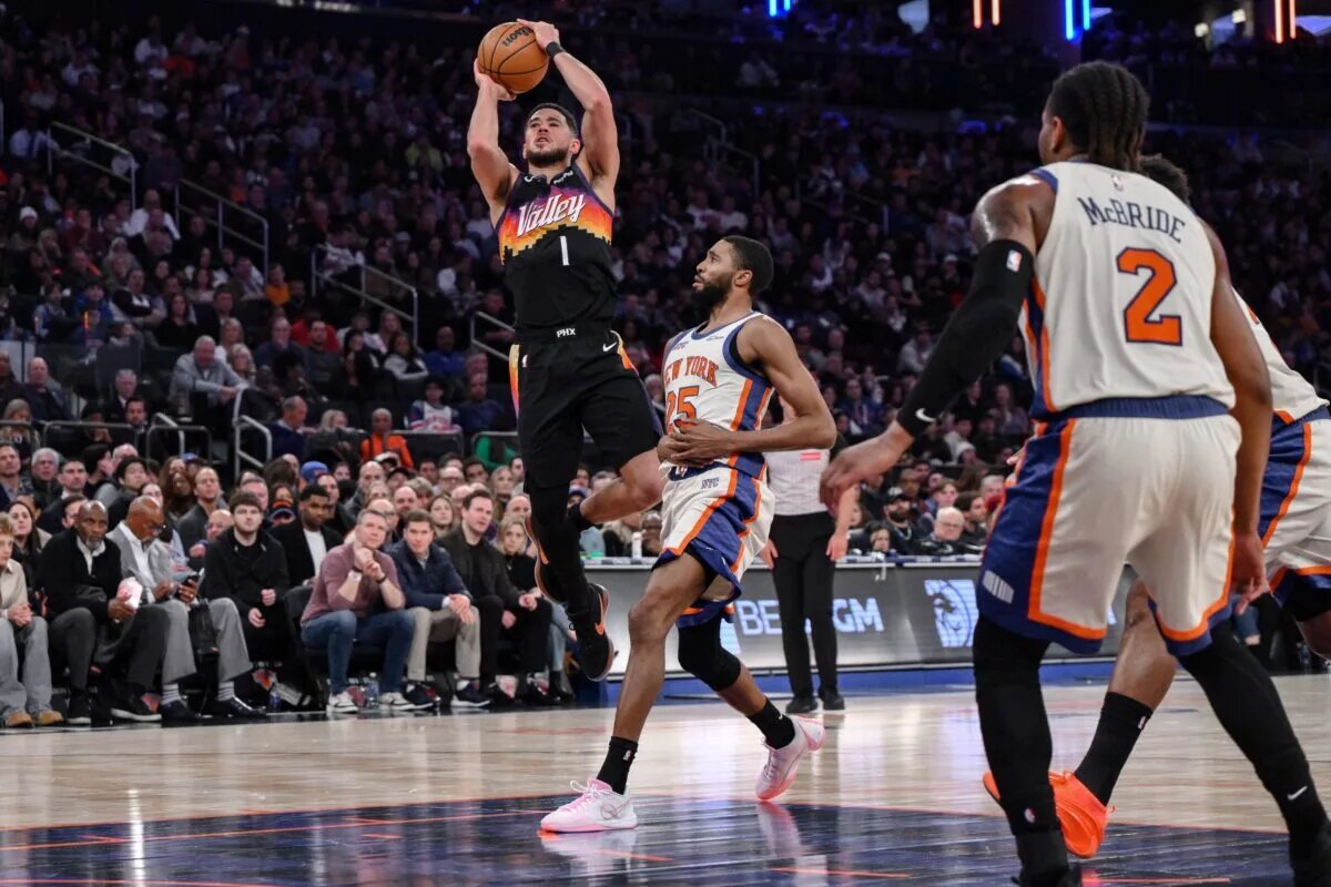 Jan 17, 2026; New York, New York, USA; Phoenix Suns guard Devin Booker (1) shoots the ball while defended by New York Knicks guard Mikal Bridges (25) during the second half at Madison Square Garden. Mandatory Credit: John Jones-Imagn Images
