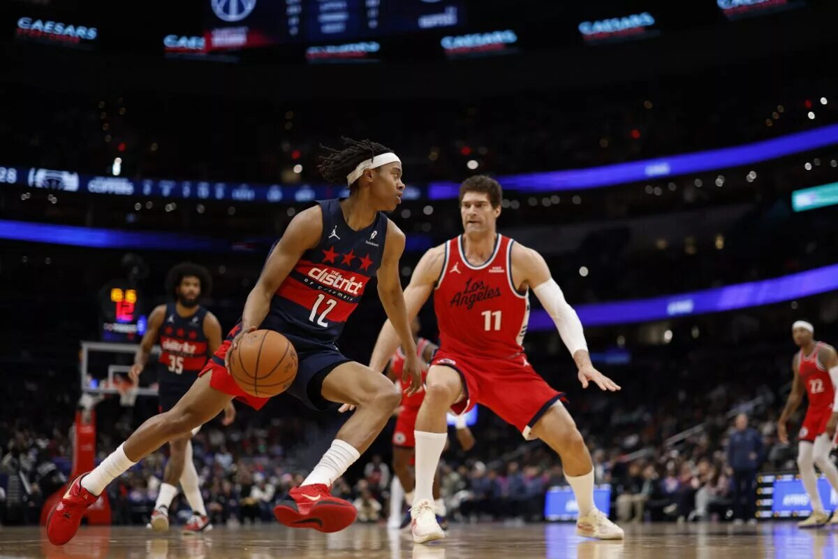 Jan 19, 2026; Washington, District of Columbia, USA; Washington Wizards guard Tre Johnson (12) drives to the basket as LA Clippers center Brook Lopez (11) defends in the first half at Capital One Arena. Mandatory Credit: Geoff Burke-Imagn Images