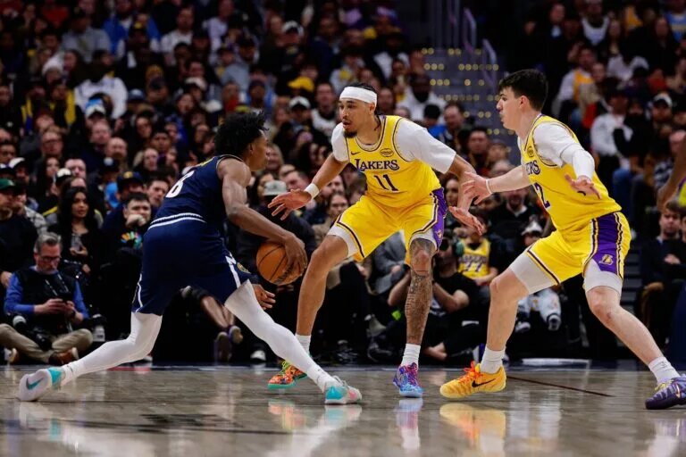 Jan 20, 2026; Denver, Colorado, USA; Denver Nuggets guard Peyton Watson (8) controls the ball as Los Angeles Lakers center Jaxson Hayes (11) and forward Jake LaRavia (12) guards in the third quarter at Ball Arena. Mandatory Credit: Isaiah J. Downing-Imagn Images