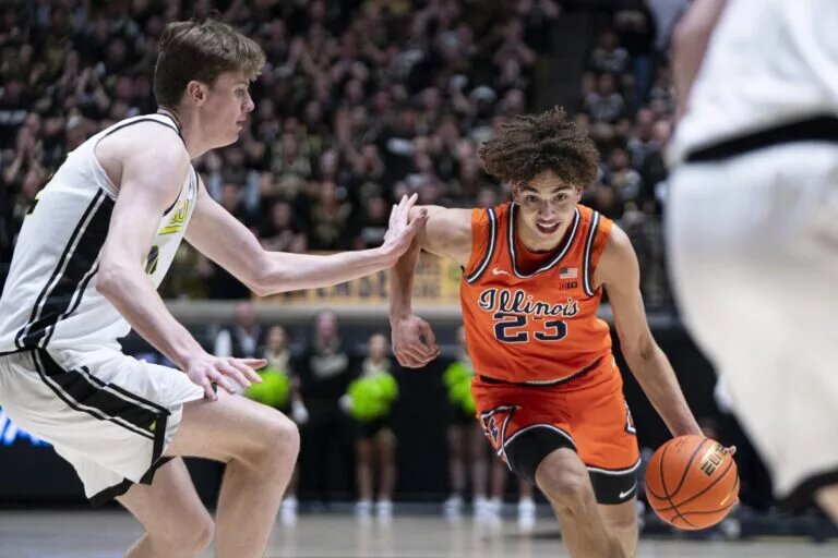 Illinois Fighting Illini guard Keaton Wagler (23) dribbles past Purdue Boilermakers center Daniel Jacobsen (12) during the first half at Mackey Arena.