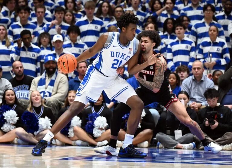 Duke Blue Devils center Patrick Ngongba II (21) drives to the basket as Louisville Cardinals guard J'Vonne Hadley (1) defends during the first half at Cameron Indoor Stadium.