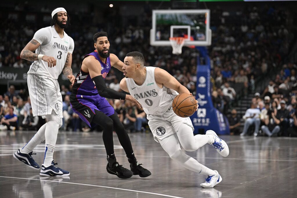 Apr 11, 2025; Dallas, Texas, USA; Dallas Mavericks guard Dante Exum (0) drives to the basket past forward Anthony Davis (3) and Toronto Raptors forward Garrett Temple (17) during the second half at the American Airlines Center. Mandatory Credit: Jerome Miron-Imagn Images