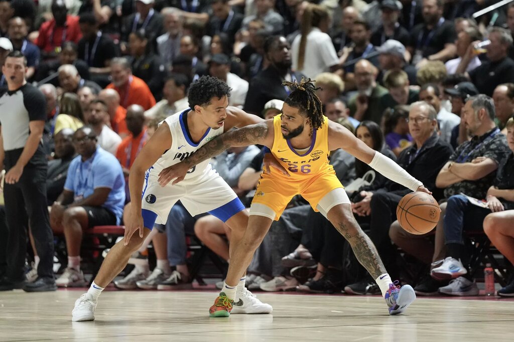 Jul 10, 2025; Las Vegas, NV, USA; Los Angeles Lakers guard RJ Davis (26) dribbles against Dallas Mavericks guard Ryan Nembhard (9) in the first quarter of their game at Thomas & Mack Center. Mandatory Credit: Candice Ward-Imagn Images