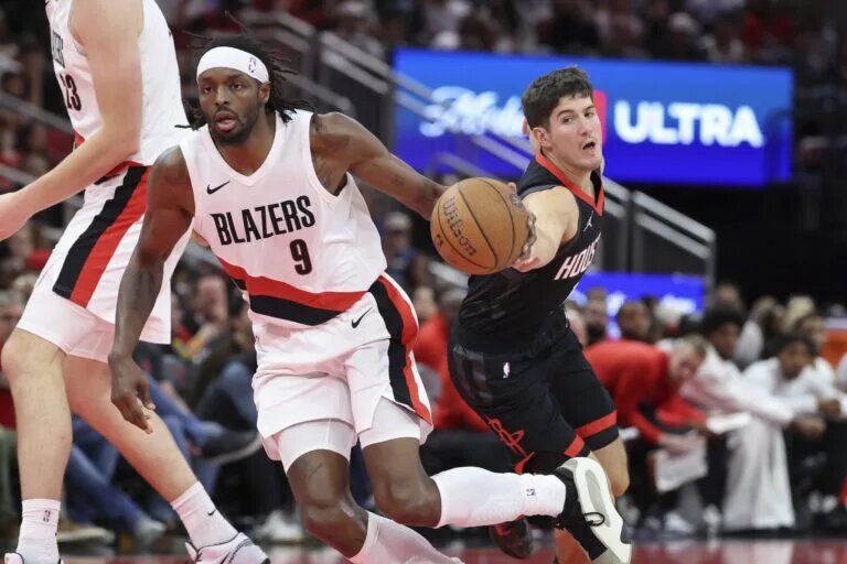 Nov 14, 2025; Houston, Texas, USA; Houston Rockets guard Reed Sheppard (15) attempts to steal the ball from Portland Trail Blazers forward Jerami Grant (9) during the fourth quarter at Toyota Center. Mandatory Credit: Troy Taormina-Imagn Images