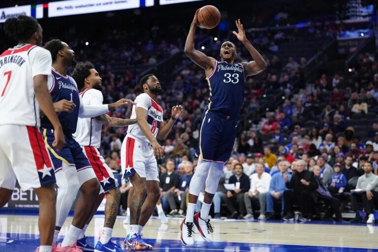Philadelphia 76ers forward Jabari Walker pulls down rebound as three Washington Wizards players look on helplessly