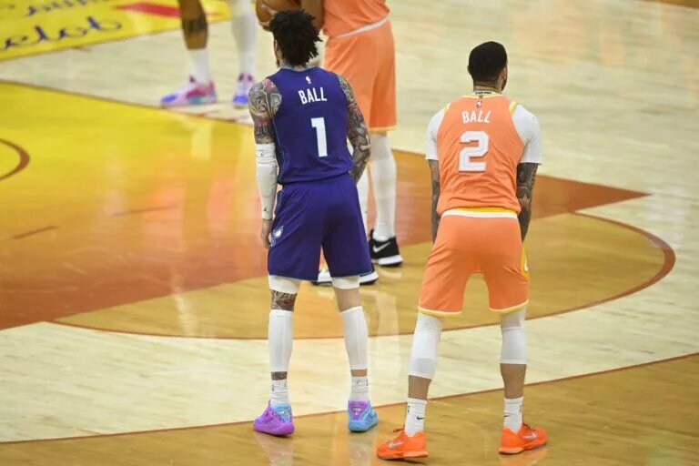 Charlotte Hornets point guard LaMelo Ball and Cleveland Cavaliers point guard Lonzo Ball side by side on the court with the backs to the camera