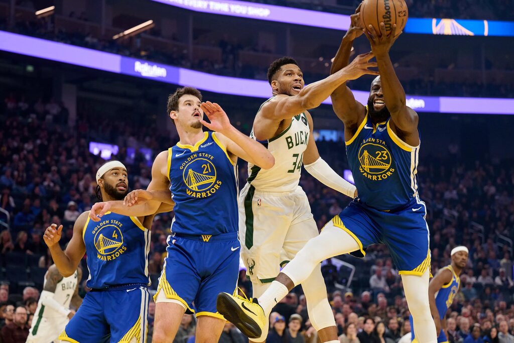 Jan 7, 2026; San Francisco, California, USA; Milwaukee Bucks forward Giannis Antetokounmpo (34) vies for a rebound against Golden State Warriors forward Draymond Green (23), center Quinten Post (21) and guard Moses Moody (4) during the first quarter at Chase Center. Mandatory Credit: Robert Edwards-Imagn Images