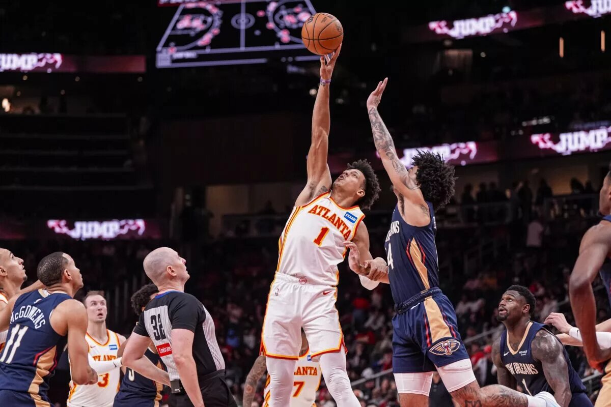Jan 7, 2026; Atlanta, Georgia, USA; Atlanta Hawks forward Jalen Johnson (1) wins a jump ball against New Orleans Pelicans guard Micah Peavy (14) during the second half at State Farm Arena. Mandatory Credit: Dale Zanine-Imagn Images