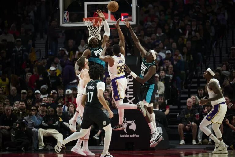 Jan 17, 2026; Portland, Oregon, USA; Los Angeles Lakers guard Marcus Smart (36) drives to the basket during the first half against Portland Trail Blazers center Robert Williams III (35) and center Duop Reath (26) at Moda Center. Mandatory Credit: Troy Wayrynen-Imagn Images
