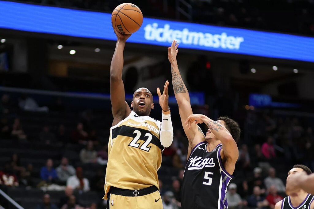 Washington Wizards forward Khris Middleton (22) takes a shot over Sacramento Kings guard Nique Clifford (5) during the first half at Capital One Arena.