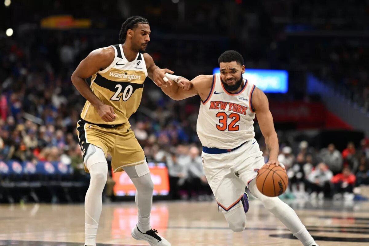 New York Knicks center Karl-Anthony Towns (32) dribbles the ball in front of Washington Wizards center Alex Sarr (20) during the third quarter at Capital One Arena.