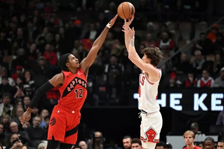 Feb 5, 2026; Toronto, Ontario, CAN; Toronto Raptors forward Collin Murray-Boyles (12) deflects a shot by Chicago Bulls forward Matas Buzelis (14) in the first half at Scotiabank Arena. Mandatory Credit: Dan Hamilton-Imagn Images