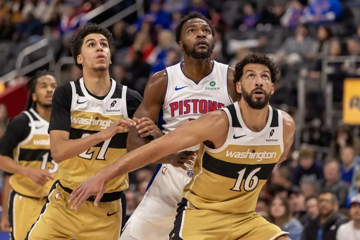 Detroit Pistons forward Paul Reed (7) battles for position between Washington Wizards guard Will Riley (27) and forward Anthony Gill (16) during the second half at Little Caesars Arena.