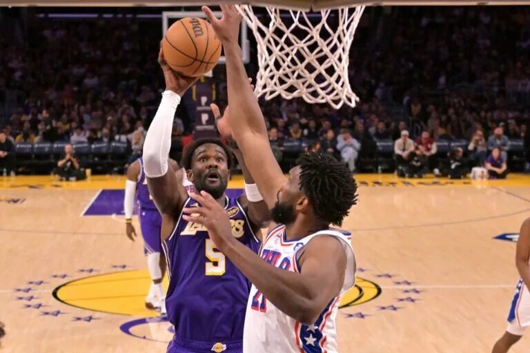 Feb 5, 2026; Los Angeles, California, USA; Los Angeles Lakers center Deandre Ayton (5) shoots over Philadelphia 76ers center Joel Embiid (21) in the second half against at Crypto.com Arena. Mandatory Credit: Jayne Kamin-Oncea-Imagn Images