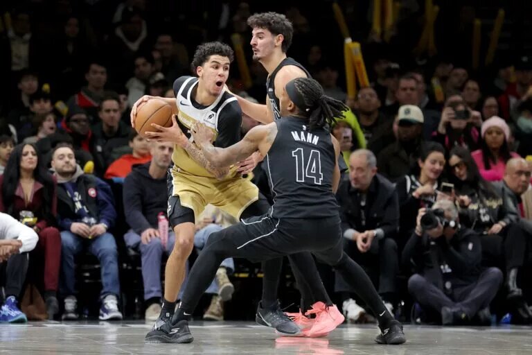 Washington Wizards guard Will Riley (27) controls the ball against Brooklyn Nets guards Ben Saraf (77) and Terance Mann (14) during the fourth quarter at Barclays Center.