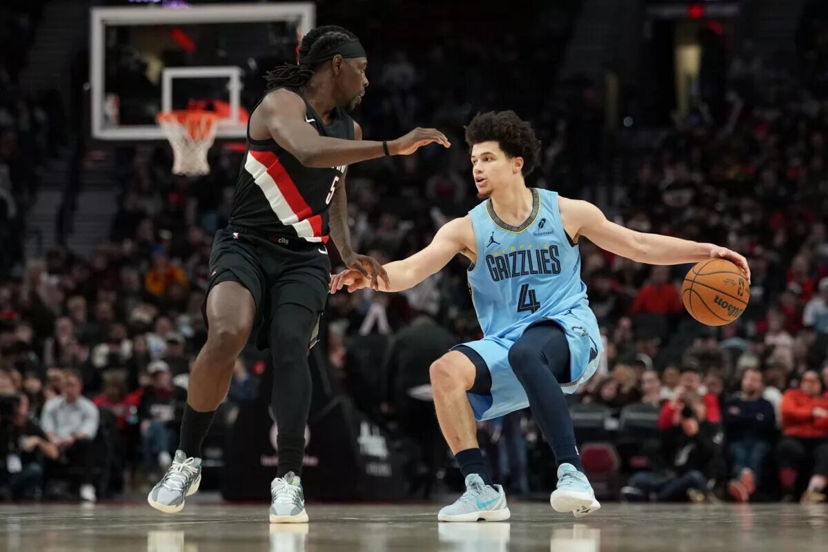 Feb 7, 2026; Portland, Oregon, USA; Memphis Grizzlies guard Walter Clayton Jr. (4) handles the ball against Portland Trail Blazers guard Jrue Holiday (5) during the second half at Moda Center. Mandatory Credit: Soobum Im-Imagn Images