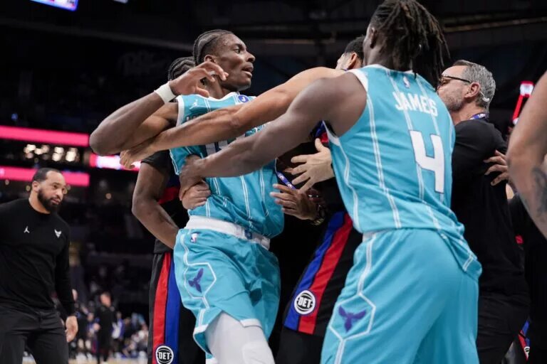 Feb 9, 2026; Charlotte, North Carolina, USA; Charlotte Hornets forward Moussa Diabaté (14) is held back by guard Sion James (4) engaging with Detroit Pistons forward Tobias Harris (12) during the second half at Spectrum Center. Mandatory Credit: Jim Dedmon-Imagn Images